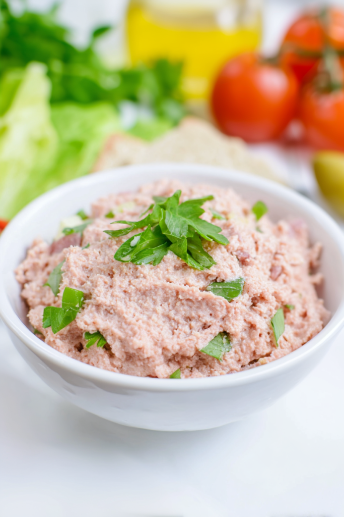 Freshly prepared salad of minced ham and mayonnaise, accented with a sprig of parsley for color.