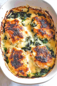 Cheesy chicken bake fresh from the oven with a rich, creamy sauce and tender greens.