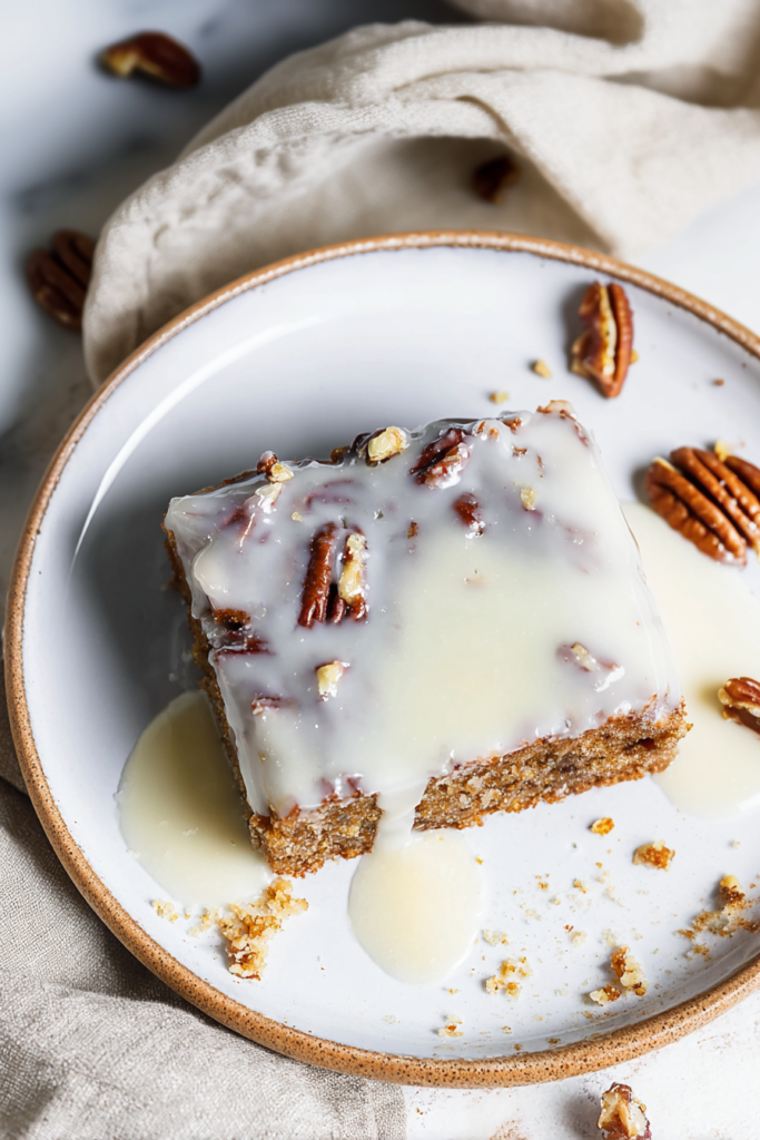 Freshly cut cake slice showing rich texture, finished with a smooth glaze and pecan garnish.