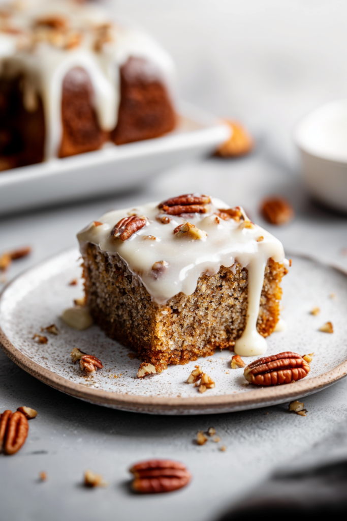 Final presentation of a nut-studded cake slice, plated simply with a pecan accent for rustic charm.