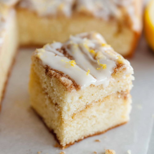 Close-up of a soft cinnamon swirl cake topped with cream cheese icing.