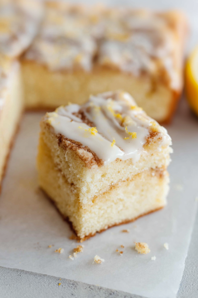 Close-up of a soft cinnamon swirl cake topped with cream cheese icing.