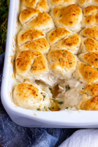 Close-up of a creamy chicken casserole topped with fluffy, golden-brown biscuits.