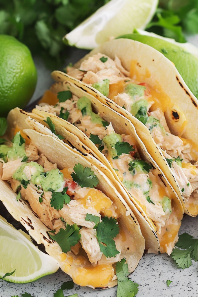 Close-up of baked tacos in a glass dish with golden, cheesy tops.