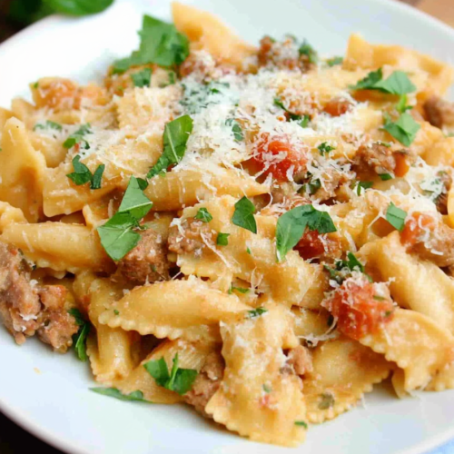 Bow-tie pasta coated in a rich tomato cream sauce with fresh parsley.
