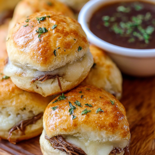 Stacked biscuits showing browned tops and hearty filling, styled with fresh herbs