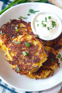 Close-up of crispy vegetable fritters, garnished with fresh herbs.