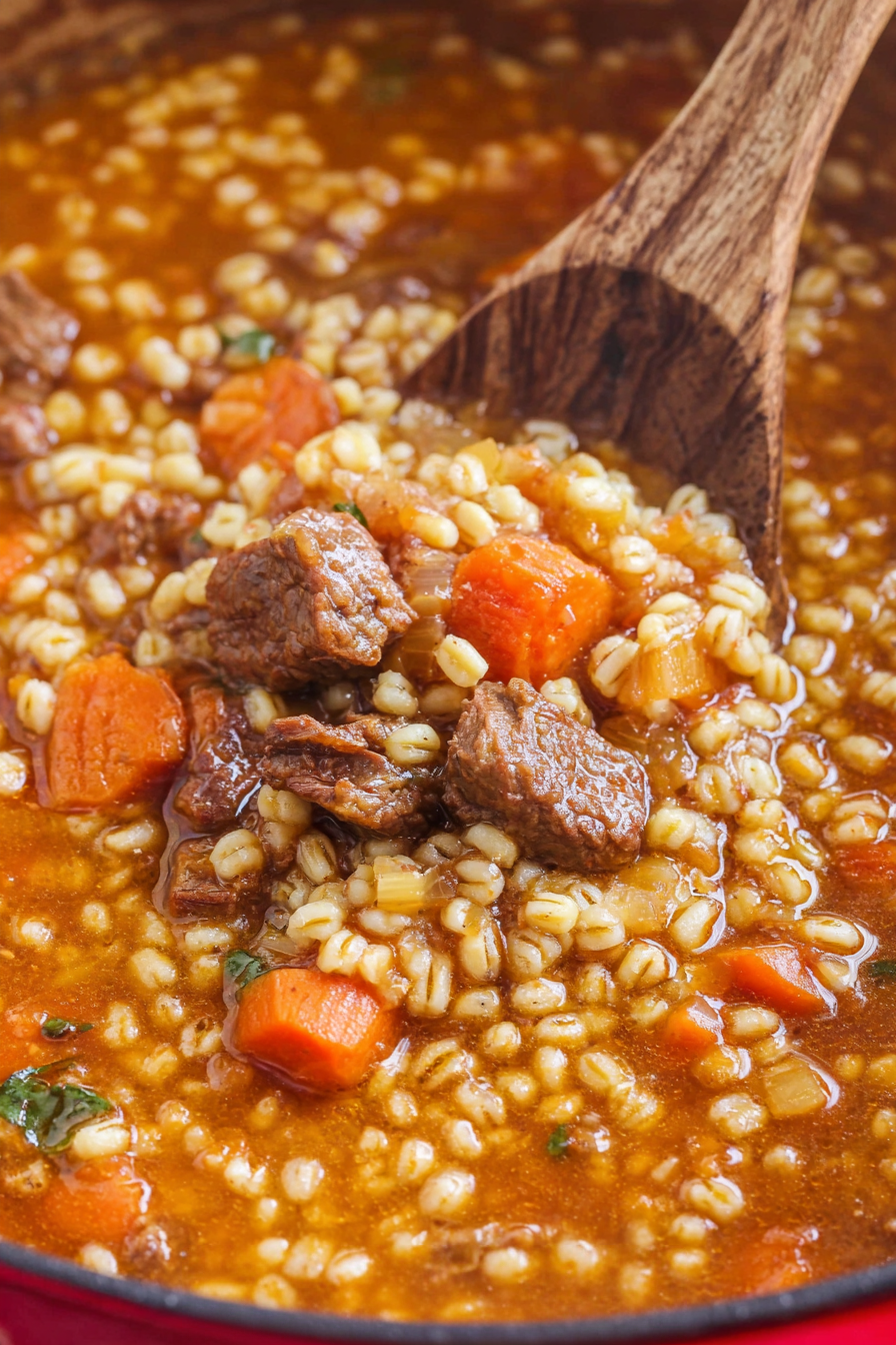 Close-up of a warm, homemade beef and barley vegetable soup garnished with fresh parsley