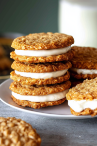Plate of golden brown cookies pressed together with a generous layer of creamy filling