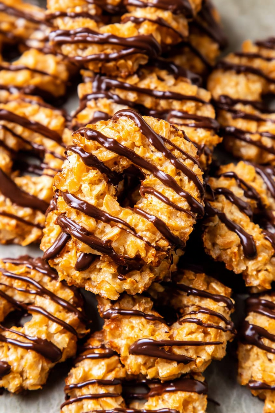 Homemade caramel and coconut treats arranged on a tray with rich chocolate drizzle.