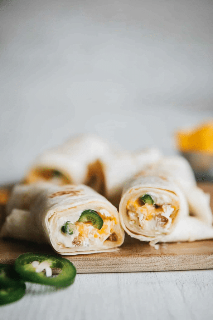 Party appetizer of tortilla spirals with vibrant vegetables and melted cheese.