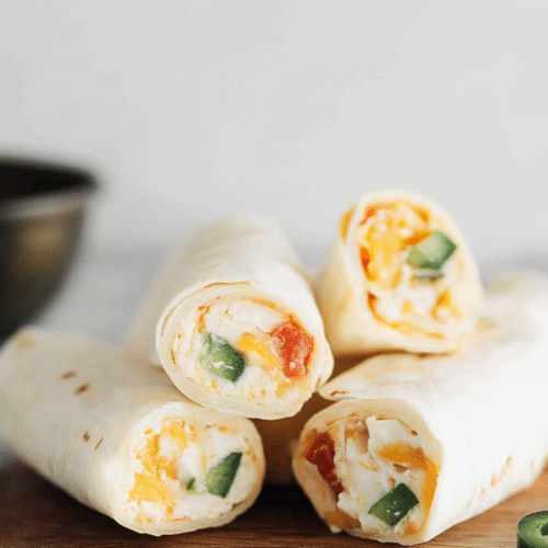 Stacked tortilla roll ups with jalapeรฑo slices and corn garnish.