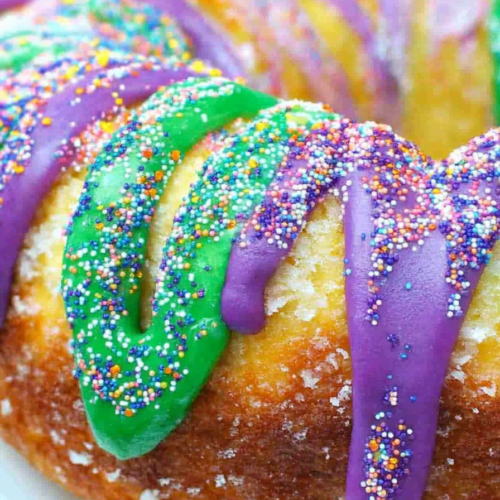 Close-up of moist cinnamon-filled cake interior with colorful icing sections on top.