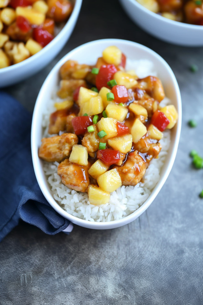 Sticky chicken bites coated in a glossy sauce and served with pineapple over steamed rice.