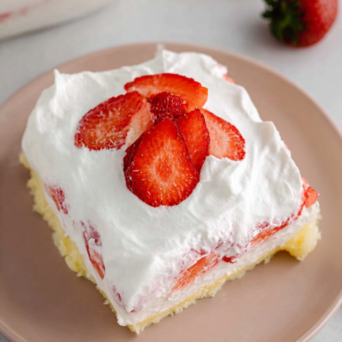 Close-up of a chilled strawberry and cream dessert slice with a soft layered filling.