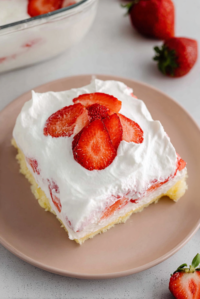 Close-up of a chilled strawberry and cream dessert slice with a soft layered filling.
