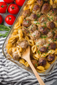 Final presentation of meatballs over saucy noodles, styled simply with a rustic cloth backdrop.