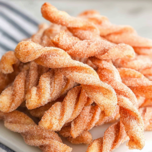 Crispy fried twists with a warm, sugary coating ready to enjoy