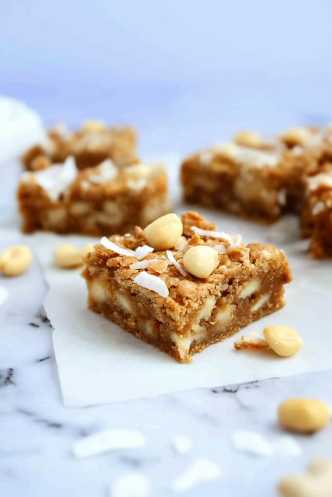 Buttery blondie bars loaded with white chocolate pieces and coconut flakes, photographed in natural light.