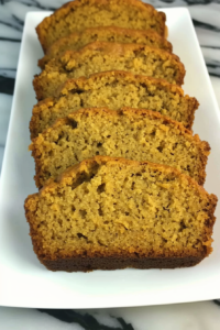 Sliced homemade loaf with a moist crumb and golden crust on a white plate