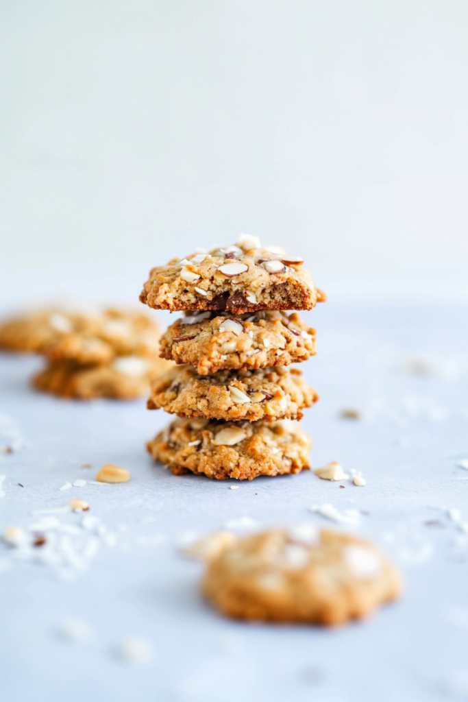 Stack of golden cookies with chocolate chips and almond slices.