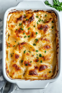 Oven-baked potato dish topped with melted cheese and fresh herbs
