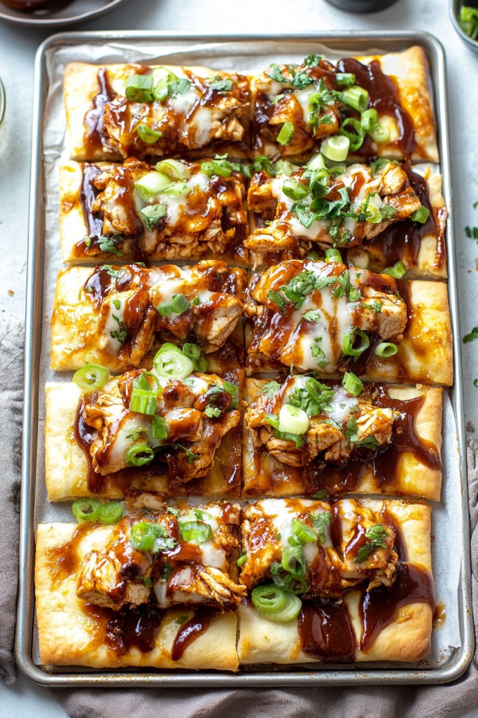 Crispy flatbread pieces arranged neatly, each slice loaded with barbecue chicken chunks and vibrant toppings.