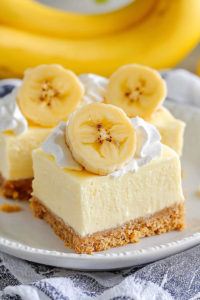 Soft cheesecake squares finished with banana slices and a light whipped topping