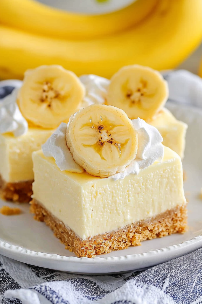 Soft cheesecake squares finished with banana slices and a light whipped topping