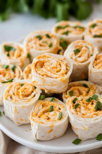 Party-ready roll-ups showing colorful filling wrapped in soft tortillas.