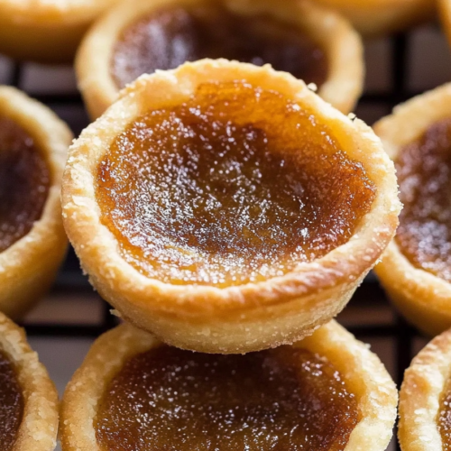 Close-up of flaky pastry shells filled with rich, sticky brown sugar filling.