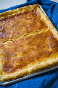 Elegant dessert presentation with a dollop of whipped cream accenting the golden-brown pie surface.
