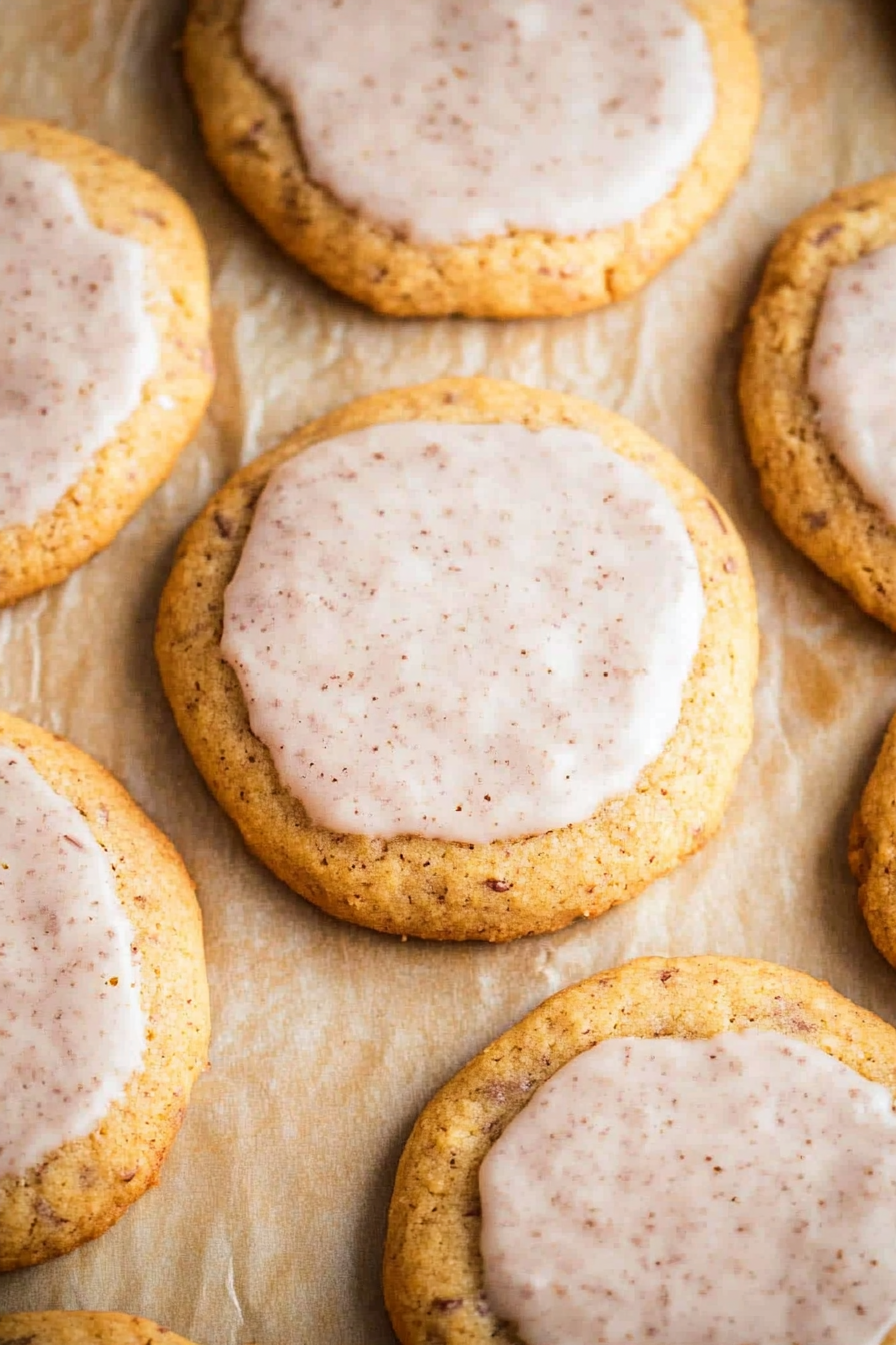 Freshly baked cookies with a smooth spiced icing spread across the top.