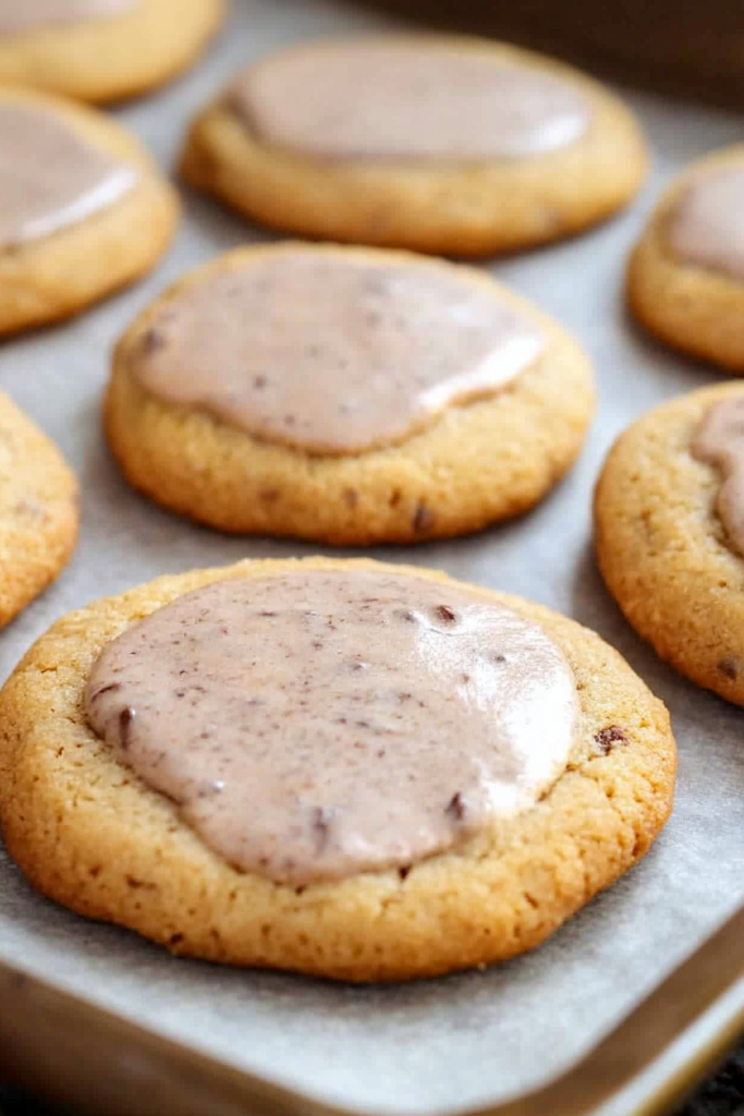 Close-up of buttery cookies topped with a smooth spiced icing.