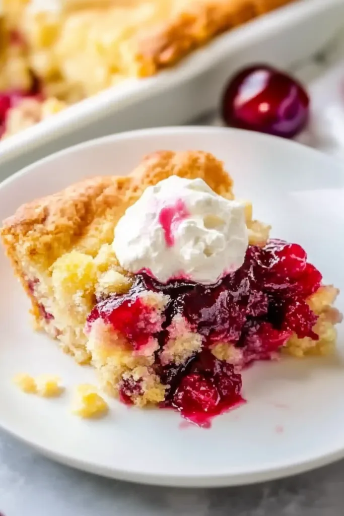 Golden-brown dessert with cherries and pineapple baked together, served in a white dish.