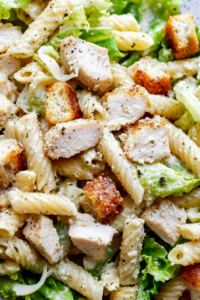 Bowl of creamy pasta salad with seasoned chicken and crunchy toppings