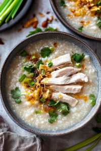 Chicken jook recipe served warm in a bowl, finished with green onion and garlic toppings.