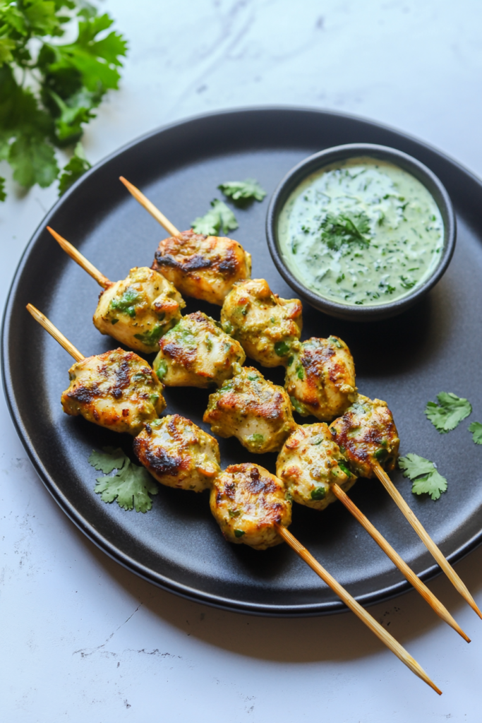 Creamy grilled chicken tikka skewers with charred edges and fresh herbs