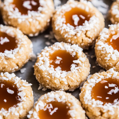 Festive cookies arranged neatly, showing coconut-coated edges and smooth caramel filling.