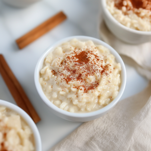 Homemade rice pudding served simply, highlighting its rich texture and subtle cinnamon garnish.