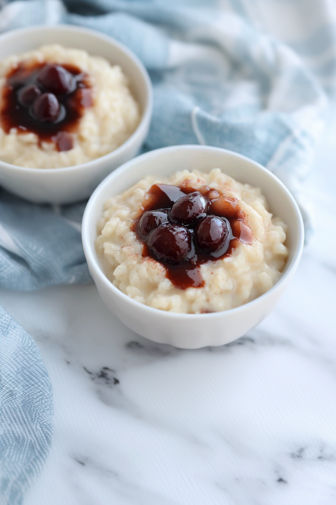 White bowl filled with comforting rice dessert, set against a soft blue cloth background.