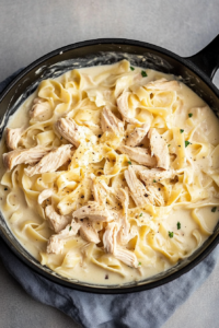 Creamy Rotisserie Chicken Alfredo served simply, highlighting tender chicken and smooth pasta sauce.