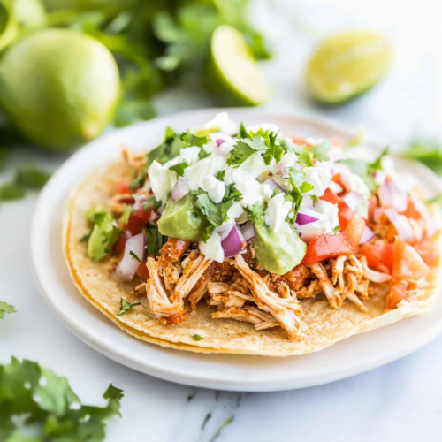 Golden tostada shell topped with juicy chicken and colorful fresh toppings 🌮