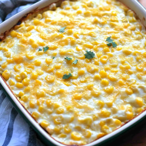 Golden baked corn dish with a creamy texture and fresh green onion garnish.