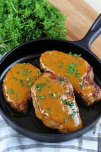 Pan-seared pork chops coated in a rich golden mustard sauce.
