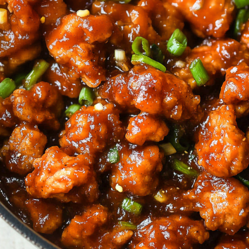 Final dish of tender chicken in a thick, savory glaze, styled with fresh herbs for color.