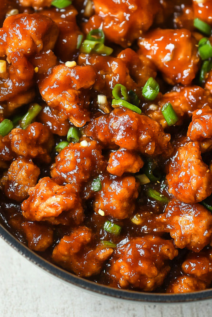 Final dish of tender chicken in a thick, savory glaze, styled with fresh herbs for color.