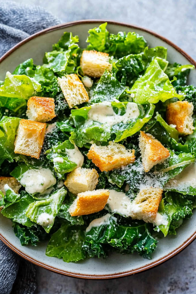 Close-up of crisp kale leaves tossed with croutons and parmesan cheese.