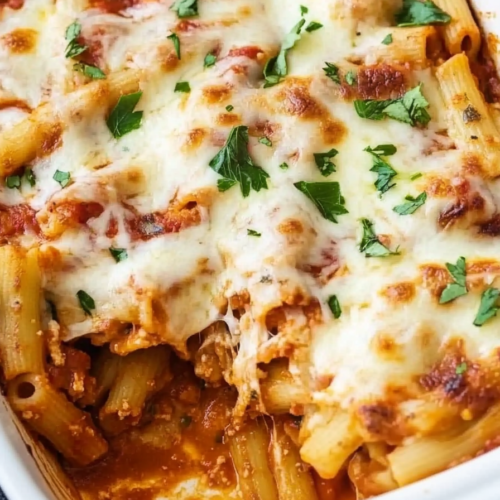 Close-up of oven-baked pasta with rich tomato sauce and golden melted cheese.