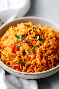 Freshly cooked rice with tomatoes, herbs, and mixed vegetables on a plate